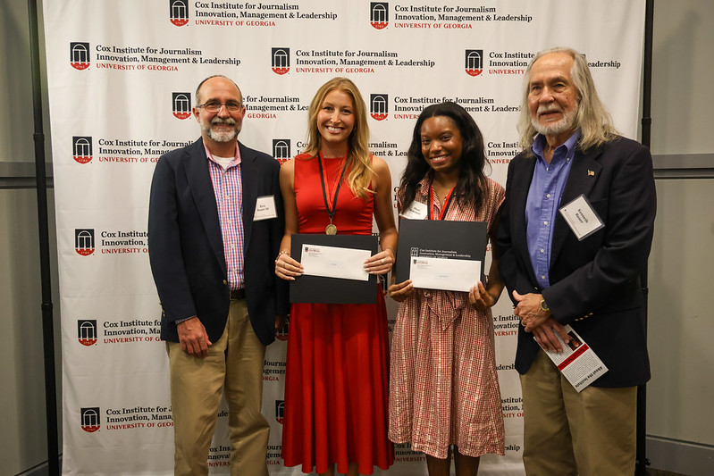 Two adults and two students holding certificates pose for a picture in front of a step-and-repeat that says Cox Institute for Journalism, Innovation & Leadership, University of Georgia.