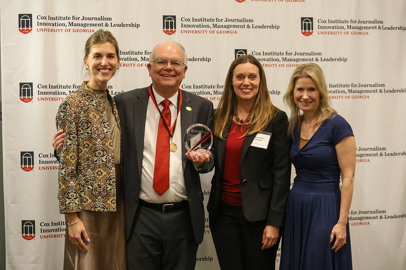 A group of faculty members pose for a picture in front of a step-and-repeat that says Cox Institute for Journalism, Innovation & Leadership, University of Georgia.