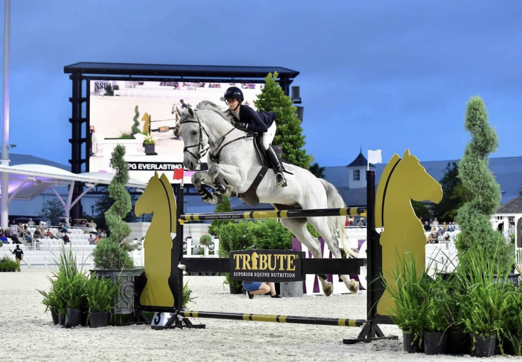 Alexia Rule is pictured on a white horse at an equestrian competition.