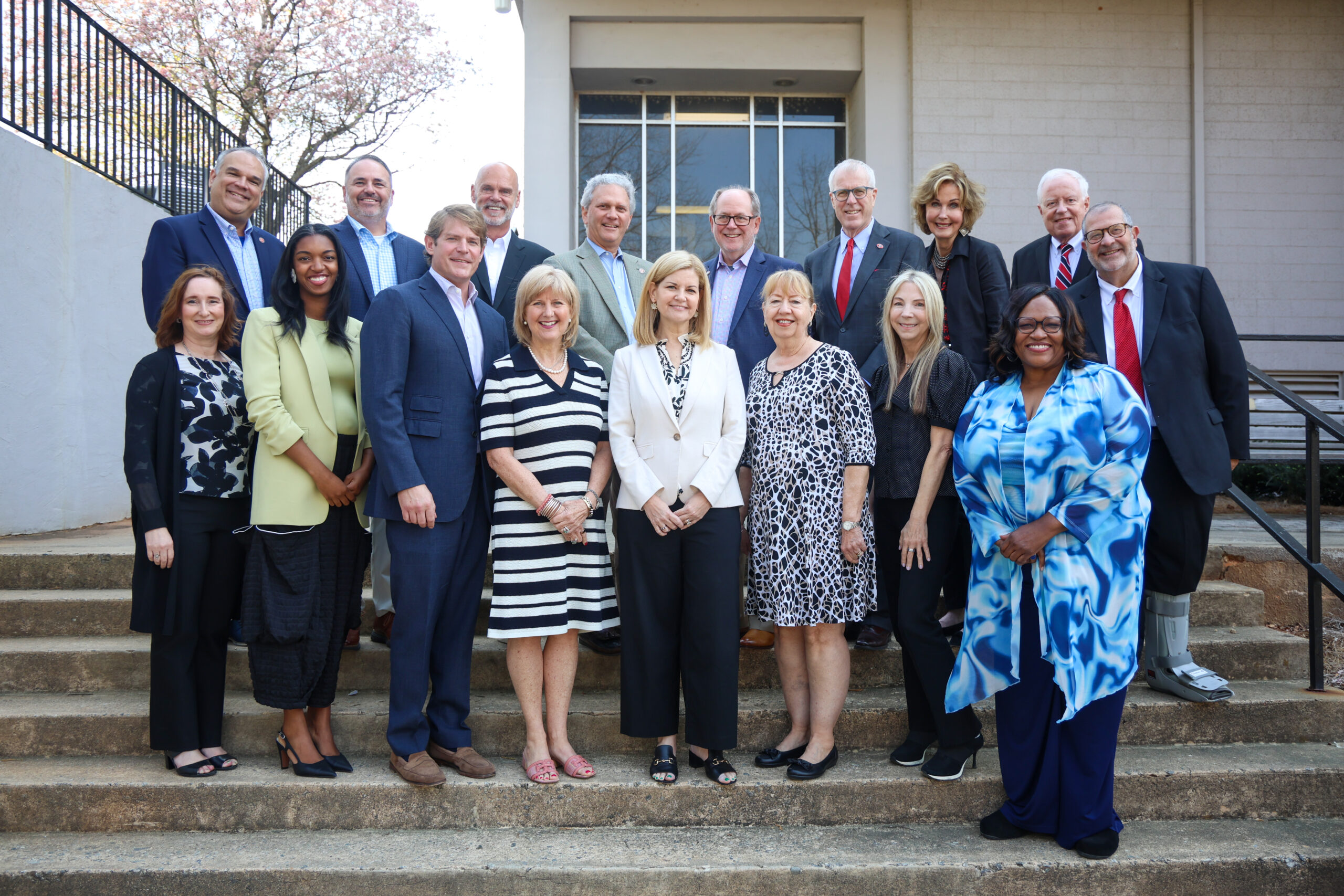 Front row (l. to r.) Kristen Manion Taylor, Crystal Ashbourne, Eric NeSmith, Jennifer M Sloan, Amanda Rosseter, Carolyn Tieger, Melissa Libby and Eugenia Harvey.A group of Board of Trust members pose for a picture outside the side entrance to Grady College.