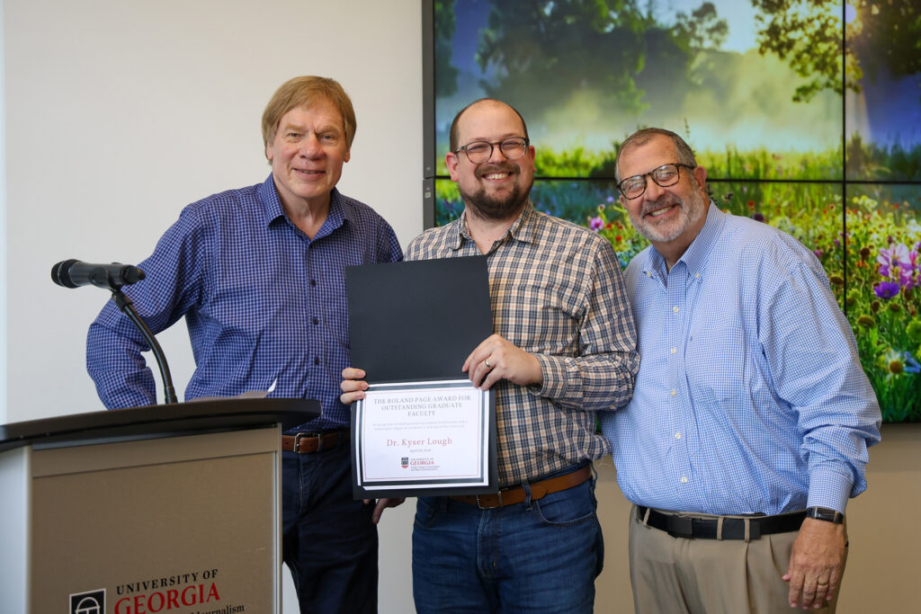 Kyser Lough stands between Glen Nowak and Dean Davis and displays his certificate fro the Roland Page Award.