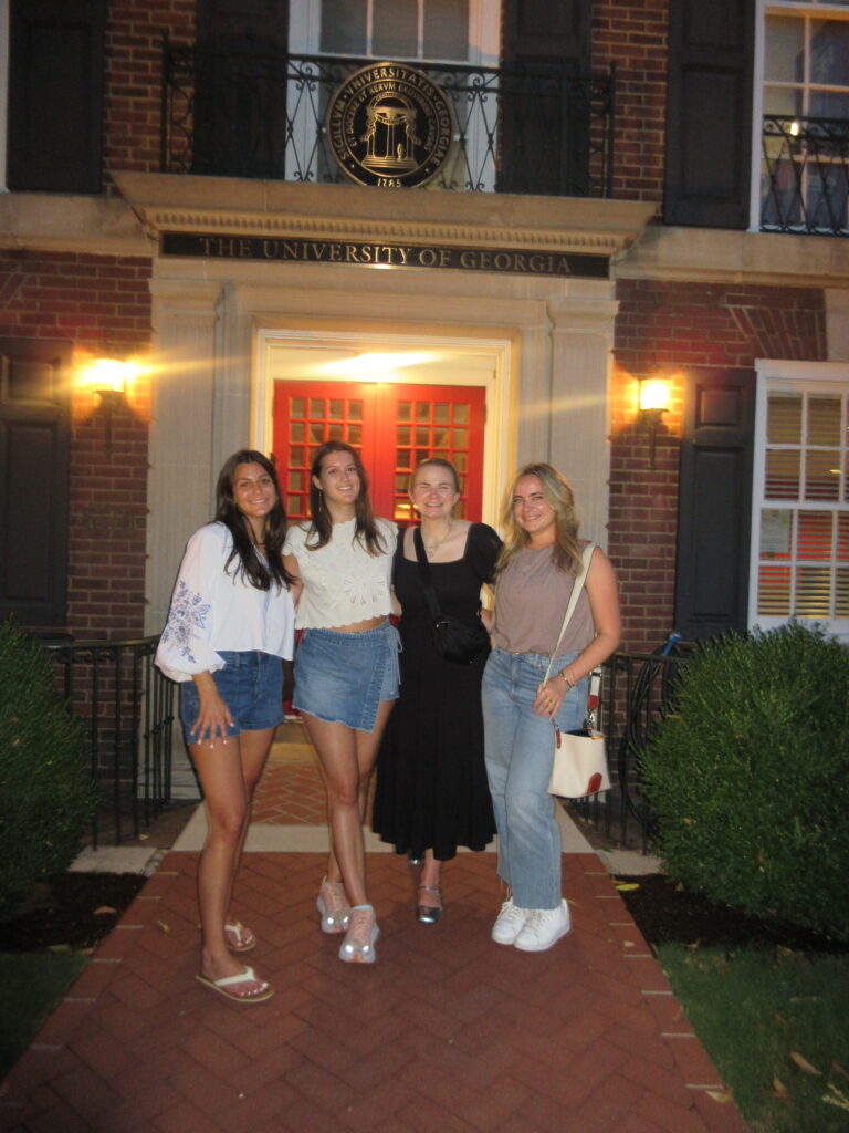 Danielle Zeitlin stands in front of a brick building with three women.
