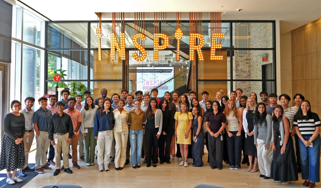 A group of college students stand in the Inspire Brands office.