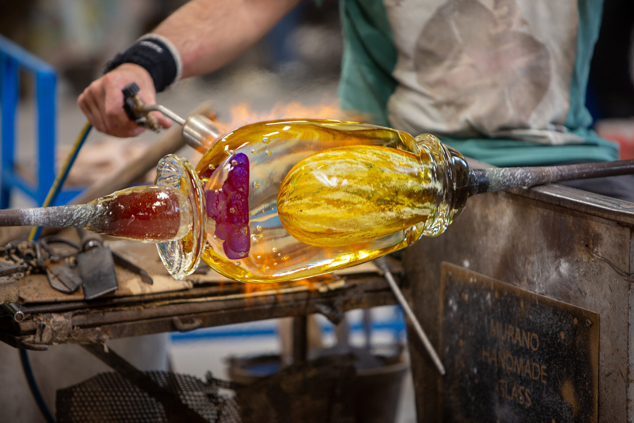 A close up of decorative glass that is being shaped by a flame.