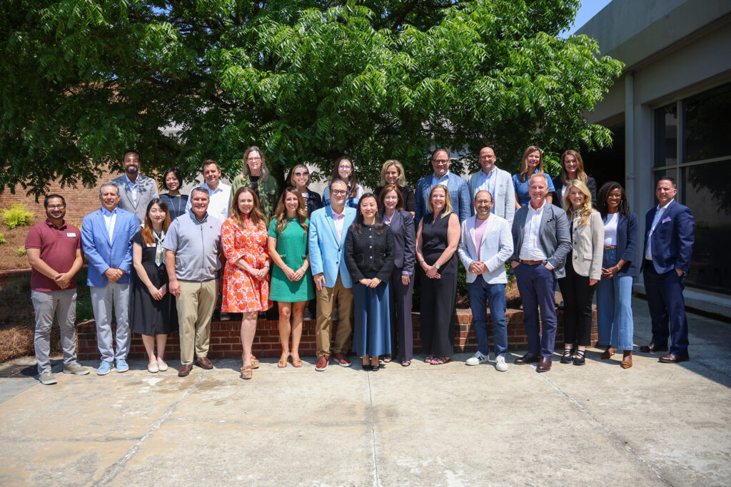 A group of advertising and PR professionals and faculty pose for a picture outside of Grady College.