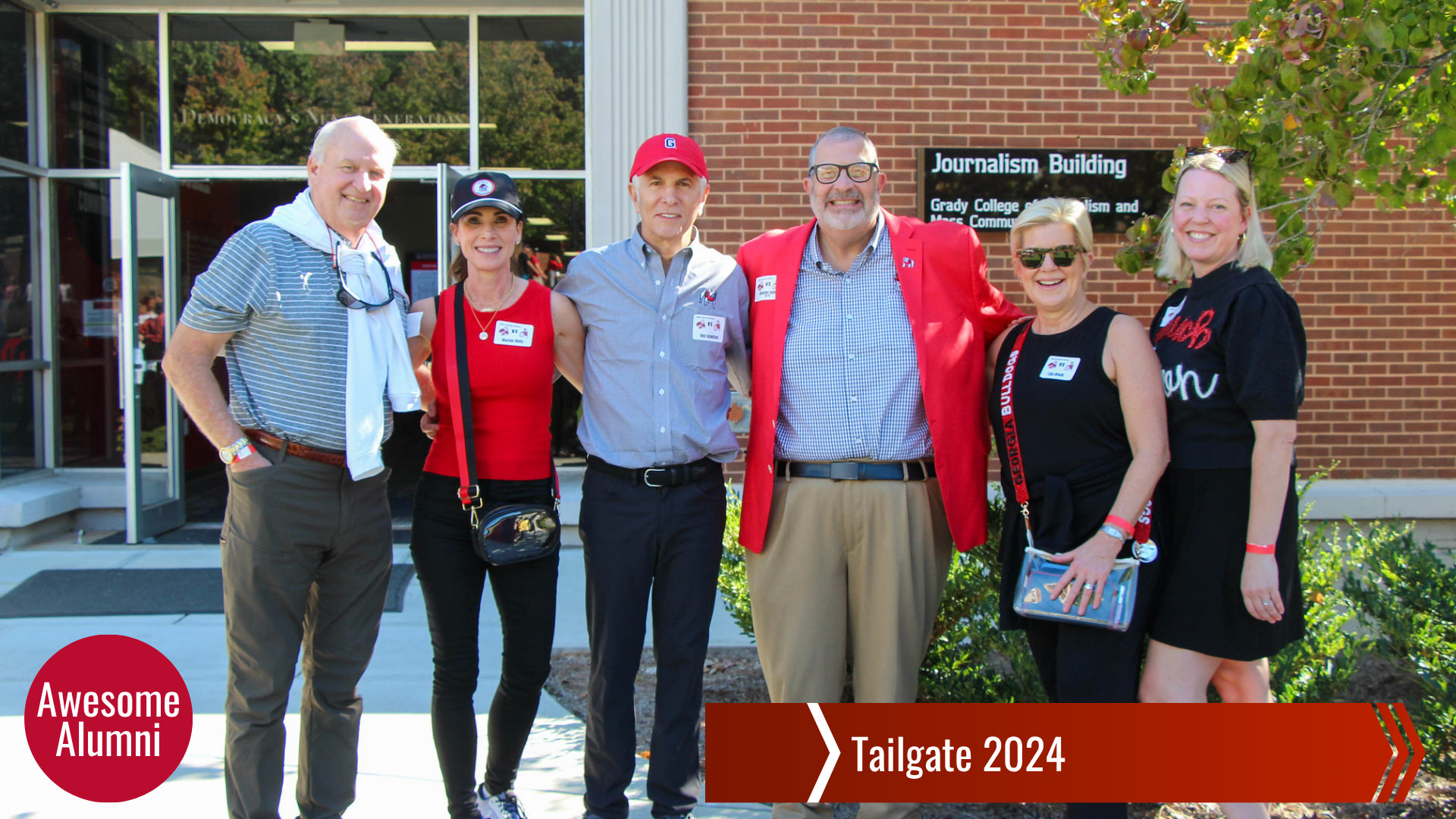 Group of people in tailgate apparel in front of Journalism Building.
