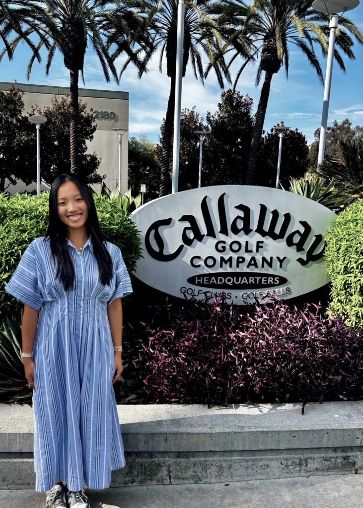 Anna La stands in front of a sign reading: Callaway Golf Company Headquarters.