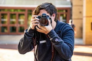 student holds up camera to take photo