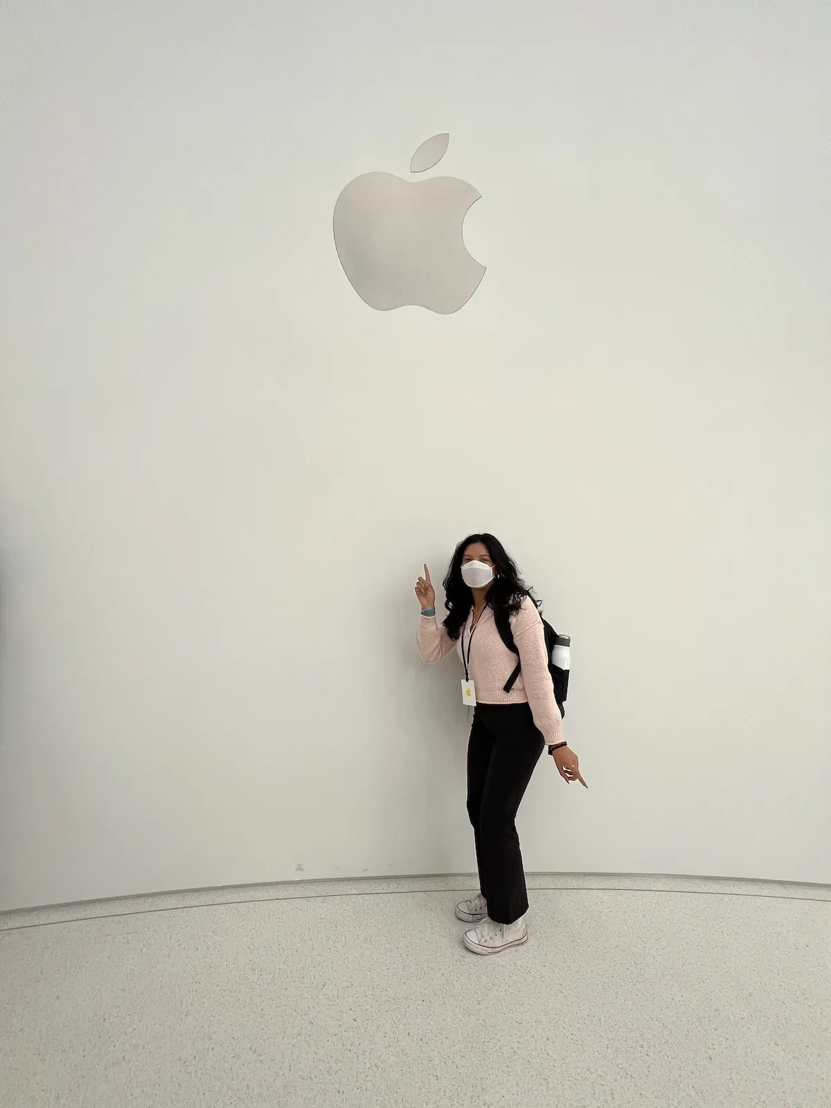 Suley poses in front of a white wall with the Apple logo