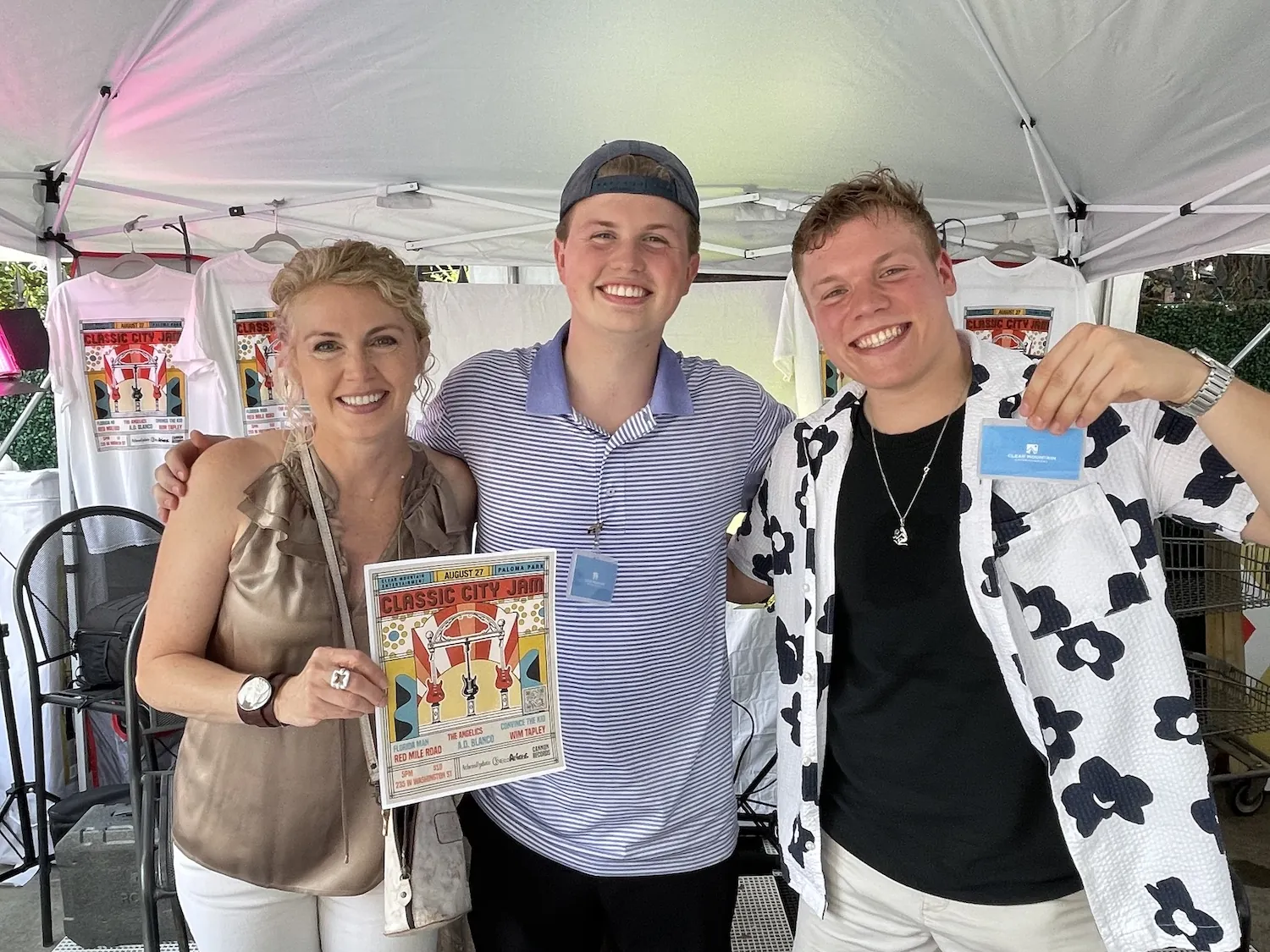 Xander with his mom, holding up a Classic City Jam poster