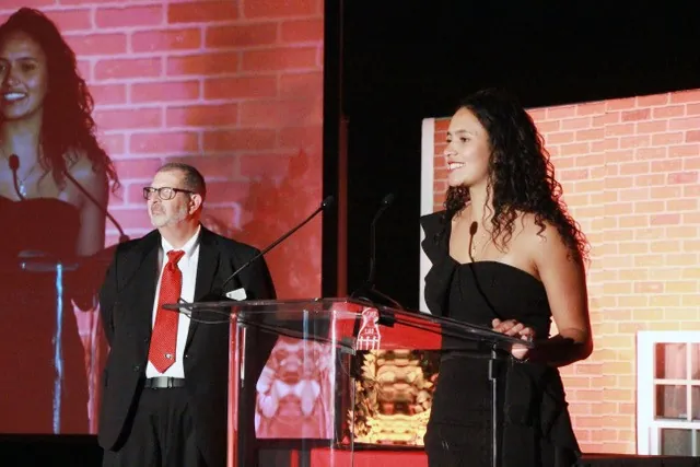 student standing in front of a podium giving a speech.