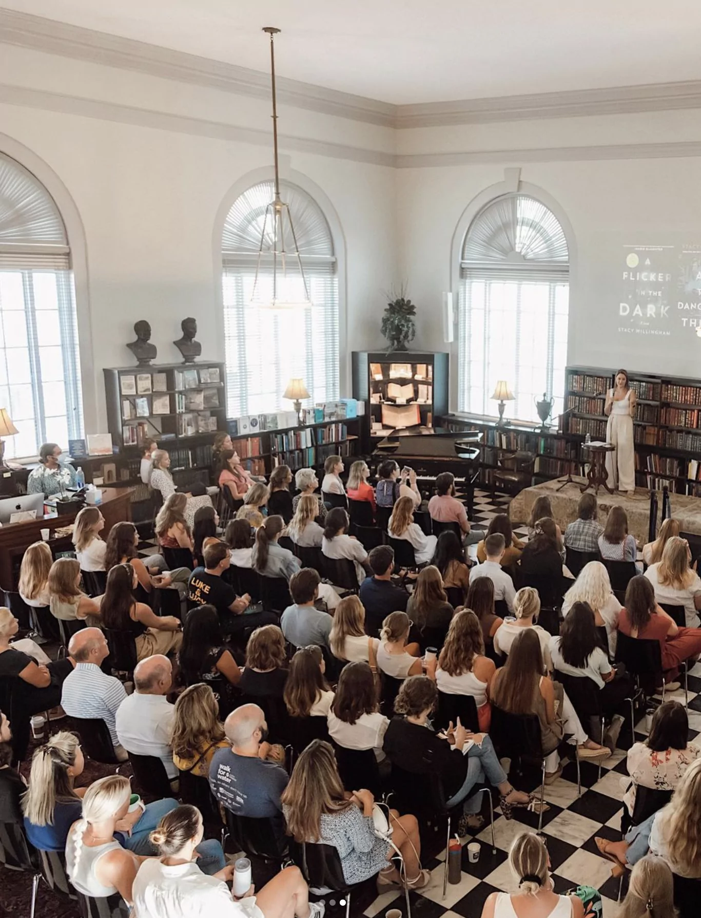 Willingham speaking to a large crowd about her novel, "A Flicker in the Dark."