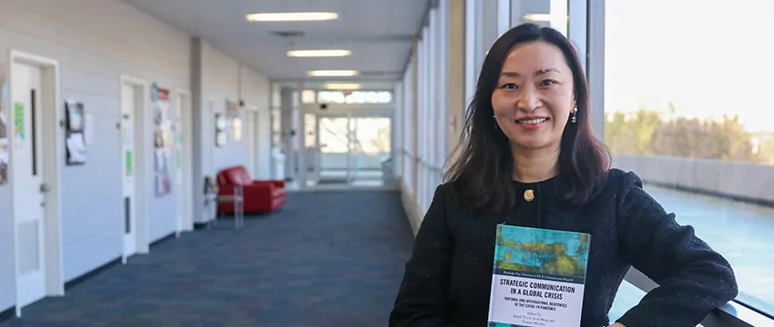 Juan Meng holds her new book.