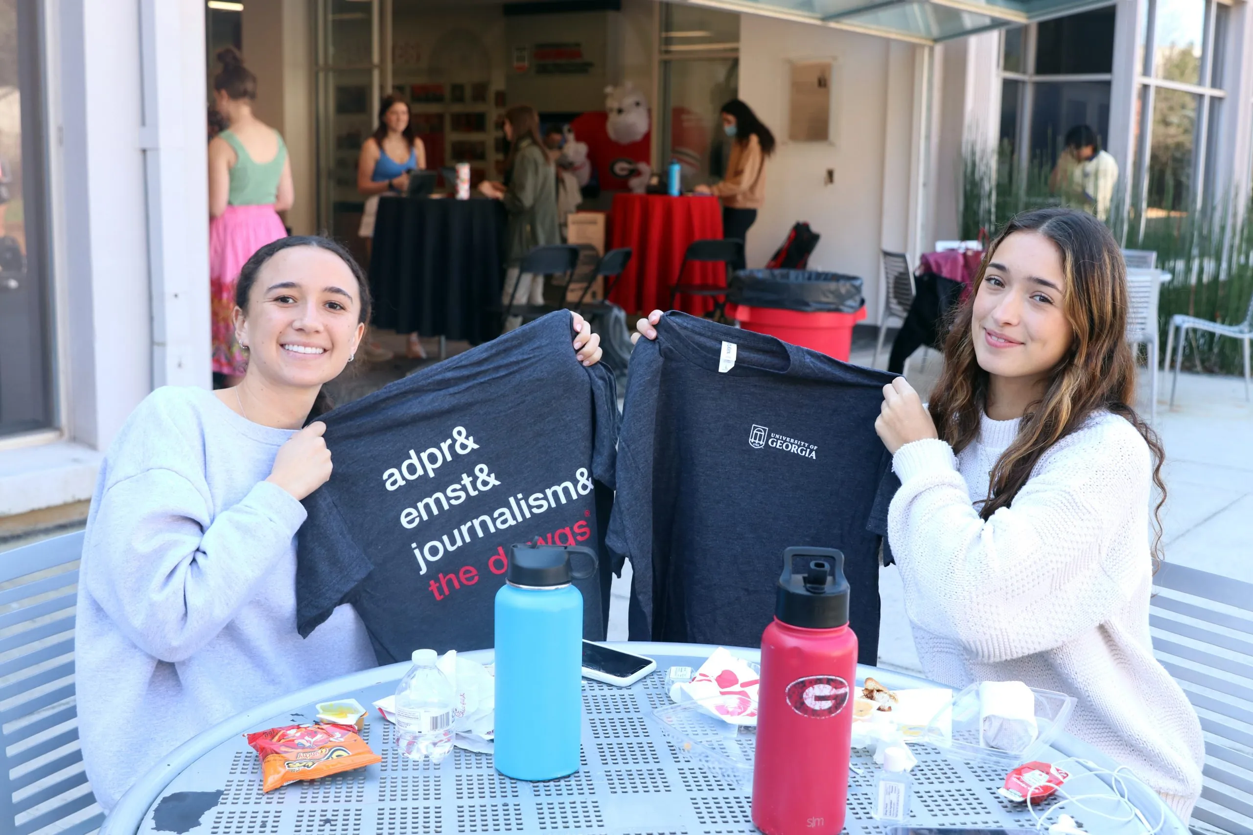 New admits to Grady College sit and show their Grady College shirts.