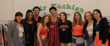Students pose at a clothing swap event.
