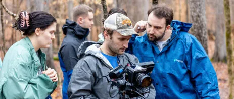 People stand around a camera during film production.