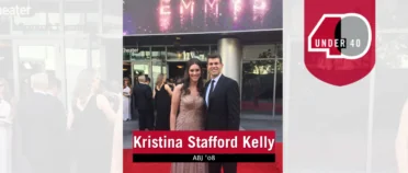 Kristina Kelly and her husband, Sean, dressed in formal attire in front of an Emmys sign.