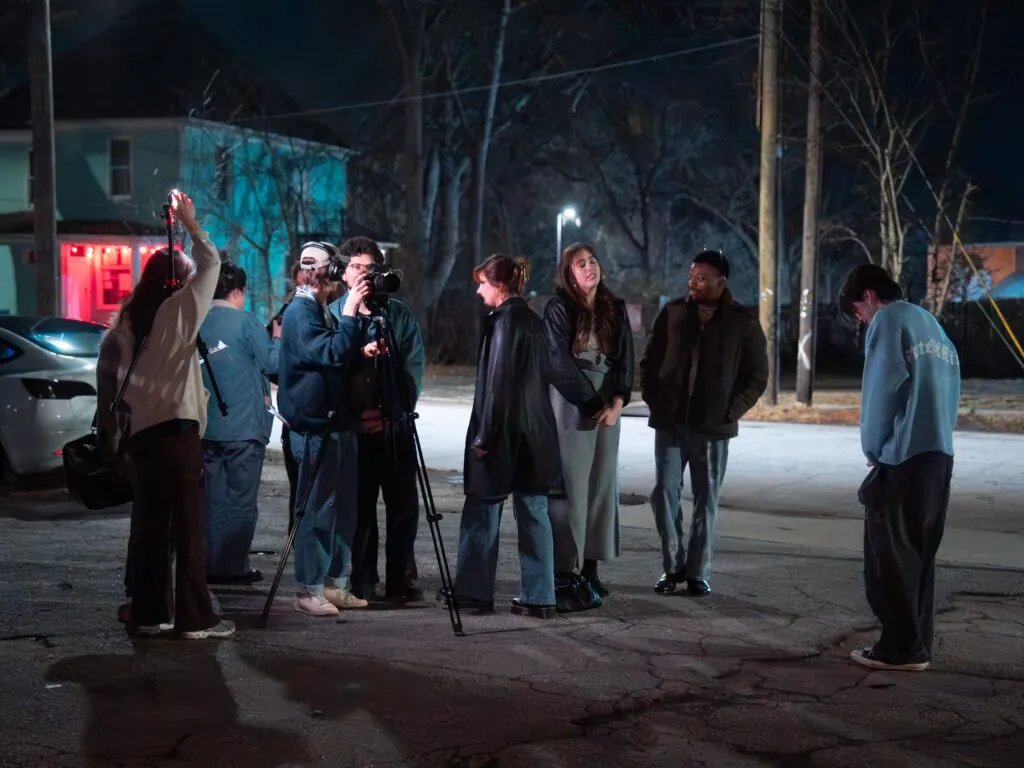 This image features eight students on a film set, where Johnson is assisting in the production.