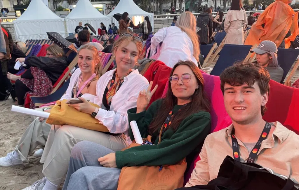 Johnson and three other students are sitting in chairs at the Cannes Film Festival.