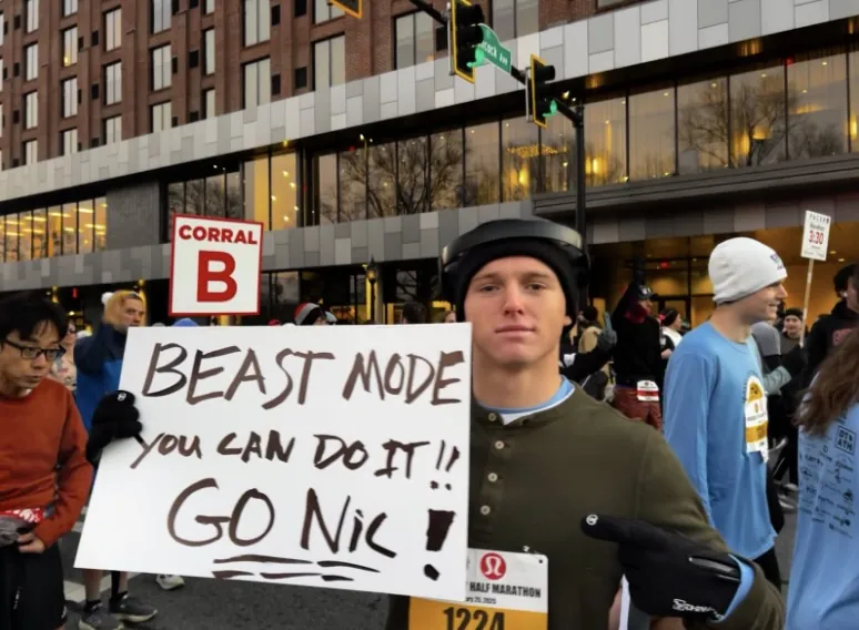 Wiles poses with a poster at the Classic City half marathon.