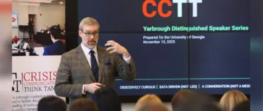 Simon Paterson makes a hand movement while he addresses a group of students. A screen in back of him reads CCTT: Yarbrough Distinguished Speaker Series.