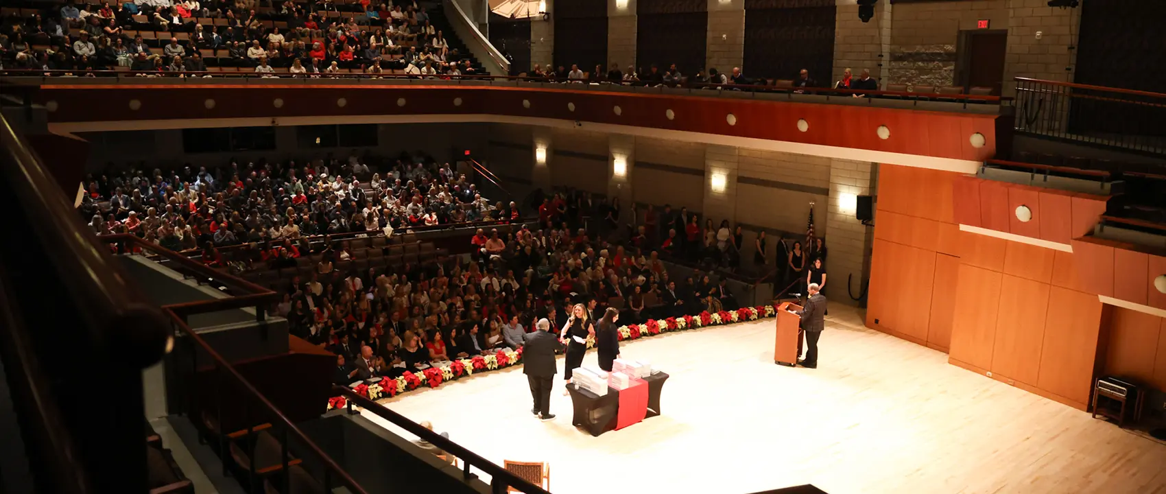 A behind the scenes view of Grady College Convocation looking at the audience.