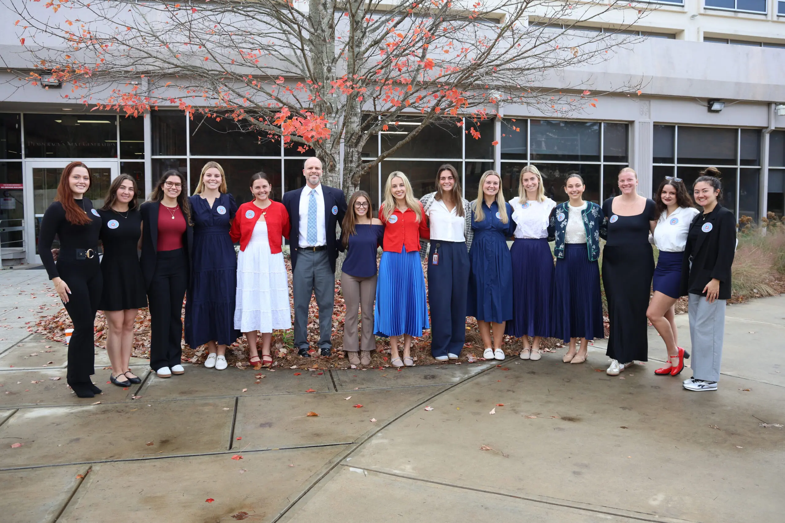 A professor and his students are pictured smiling outside Grady College.