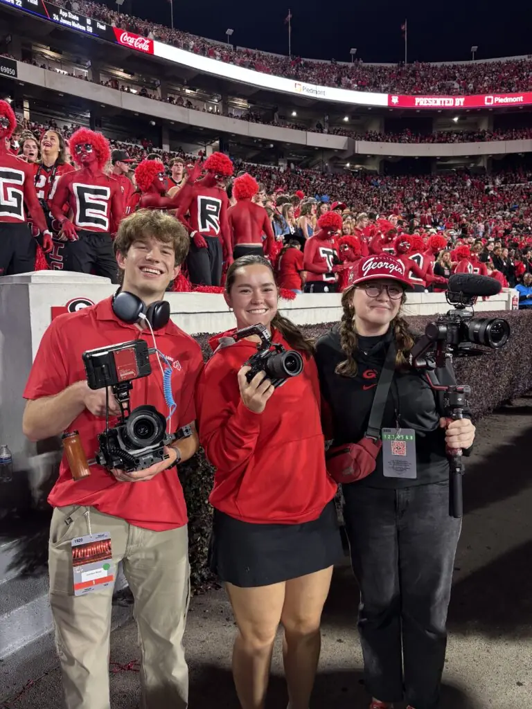 students pose with cameras at UGA football game