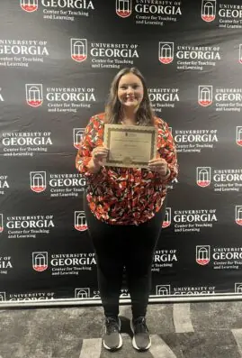 Lexie Little poses with a certificate.