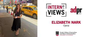 White InternViews graphic for Elizabeth Nark, an intern at Cyera accompanied by a picture of Elizabeth Nark standing outside in New York City holding her badge.