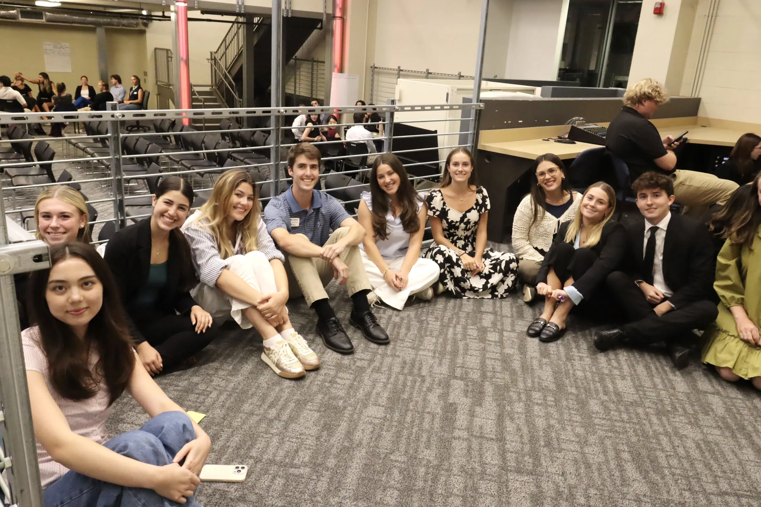 Group of Talking Dog students sitting on the floor smile and pose for a picture.